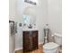 Bathroom with wood floors, sink, vanity, toilet and oval mirror at 5085 Red Rock Dr, Larkspur, CO 80118