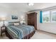 Bedroom with a patterned bedspread, blue curtains, and large wardrobe for storage at 5085 Red Rock Dr, Larkspur, CO 80118