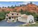 Stunning home with a red tile roof, a three-car garage, and beautifully landscaped yard situated by a majestic red rock formation at 5085 Red Rock Dr, Larkspur, CO 80118