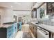 Bright and open kitchen with blue and wood cabinets, marble countertops, stainless steel appliances, and a view of the patio at 5085 Red Rock Dr, Larkspur, CO 80118
