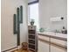 Laundry room sink and cabinets, next to a cactus-shaped coat rack and window at 5085 Red Rock Dr, Larkspur, CO 80118