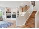 Spacious living room features a fireplace, shelving, and a staircase with wood and white accents at 5085 Red Rock Dr, Larkspur, CO 80118