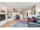 Open living space with light hardwood floors, a fireplace, and staircase with decorative shelves at 5085 Red Rock Dr, Larkspur, CO 80118