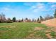 Expansive backyard featuring a lush green lawn, mature trees, and partial fencing at 6196 S Rosewood Dr, Littleton, CO 80121