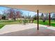 Charming backyard with a spacious patio, green lawn, mature trees, and outdoor seating area at 6196 S Rosewood Dr, Littleton, CO 80121