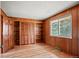 Wood-paneled bedroom with built-in shelving and a window providing natural light at 6196 S Rosewood Dr, Littleton, CO 80121
