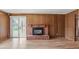 Living room with wood paneling, a brick fireplace, and sliding glass door to the outside at 6196 S Rosewood Dr, Littleton, CO 80121