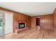 Living room featuring a brick fireplace, wood paneling, and hardwood floors at 6196 S Rosewood Dr, Littleton, CO 80121