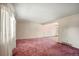 Spacious living room featuring plush pink carpet and large windows with sheer curtains at 6196 S Rosewood Dr, Littleton, CO 80121