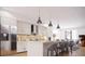 Well-lit kitchen featuring an island with seating, marble counters, stainless steel appliances and modern pendant lights at 2145 High St, Denver, CO 80205