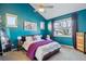 Bright bedroom with a king-size bed, purple accents and large windows for lots of natural light at 2321 Alton St, Denver, CO 80238