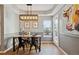 Dining room with a wooden table, black chairs and a modern light fixture with lots of natural light at 2321 Alton St, Denver, CO 80238