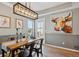 Bright dining room with a wooden table, black chairs and a modern light fixture above the table at 2321 Alton St, Denver, CO 80238