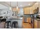 Bright kitchen featuring stainless steel appliances, wood cabinets and an island with barstool seating at 2321 Alton St, Denver, CO 80238