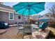 Backyard patio with stylish outdoor seating, a blue umbrella and string lights above at 2321 Alton St, Denver, CO 80238