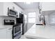 Bright kitchen showcasing stainless steel appliances, quartz countertops, and stylish white cabinetry at 1111 Maxwell Ave # 233, Boulder, CO 80304