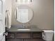 Neutral powder room features a sleek vanity with a round mirror and modern fixtures, providing a clean aesthetic at 1803 Avenida Del Sol, Castle Rock, CO 80104