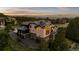 Expansive home features a dark roof and light siding, plus mountain views and mature trees in the background at 1803 Avenida Del Sol, Castle Rock, CO 80104