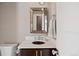 This modern powder room features a dark sink, beautiful mirror, and a sleek white countertop at 1803 Avenida Del Sol, Castle Rock, CO 80104