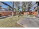 Large, fenced backyard with mature trees and a concrete patio at 6417 S Florence Way, Englewood, CO 80111