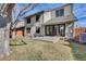 Back exterior view of house with large glass doors, patio, and lawn at 6417 S Florence Way, Englewood, CO 80111