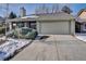Ranch home exterior featuring a two-car garage, mature landscaping, and an ADT security system at 6417 S Florence Way, Englewood, CO 80111