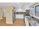 Bright kitchen with stainless steel appliances, light wood floors, and granite countertops at 6417 S Florence Way, Englewood, CO 80111