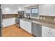 Modern kitchen featuring white cabinets, stainless steel appliances, and stone countertops at 6417 S Florence Way, Englewood, CO 80111