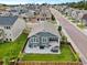 Aerial view of a blue gray home with a backyard patio and hot tub in a neighborhood with green lawns at 965 Peach Leaf Ln, Elizabeth, CO 80107