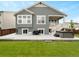 An outdoor patio with a hot tub and grill on a gray home's backyard with a well-manicured lawn at 965 Peach Leaf Ln, Elizabeth, CO 80107