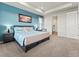 Bright bedroom features tray ceilings, ensuite bath access, and blue accent wall at 965 Peach Leaf Ln, Elizabeth, CO 80107