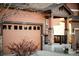 Attached two-car garage featuring a carriage door, stylish brick accents, and an inviting covered entry at 3231 Riverwood Way, Castle Rock, CO 80109