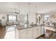 Open-concept living space with a kitchen island seamlessly connecting to the dining and living areas at 3231 Riverwood Way, Castle Rock, CO 80109