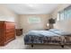 Bedroom with large windows, plush carpet, dresser, and ceiling light fixture at 10330 Melody Dr, Northglenn, CO 80260