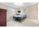 Carpeted bedroom with multiple windows, a dresser, and a wall mounted television at 10330 Melody Dr, Northglenn, CO 80260
