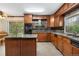 Traditional kitchen with wood cabinets, granite countertops, a center island, and stainless steel appliances at 10330 Melody Dr, Northglenn, CO 80260
