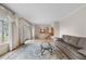 Bright living room boasts large window with drapes and wood floors at 10330 Melody Dr, Northglenn, CO 80260