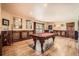 Spacious game room with pool table, wood-paneled walls, and a decorative hardwood floor at 3191 W 151St Ct, Broomfield, CO 80023