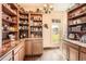 This elegant pantry offers abundant shelving, custom cabinets, granite countertops, and a cozy window view at 3191 W 151St Ct, Broomfield, CO 80023