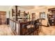 Basement wet bar with marble countertop, paneled bar, barstool seating, and hardwood floors at 3191 W 151St Ct, Broomfield, CO 80023