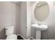 Powder room with modern pedestal sink, lighting, mirror and convenient toilet placement at 185 Ambrose St, Erie, CO 80516