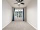 Neutral bedroom featuring a ceiling fan and a window with blue curtains at 185 Ambrose St, Erie, CO 80516