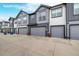 Street view of gray townhouse garages with ample parking space at 185 Ambrose St, Erie, CO 80516