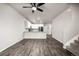 Open-concept living area with kitchen view, featuring modern hardwood floors and staircase at 185 Ambrose St, Erie, CO 80516