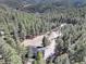 A winding drive meanders through towering trees, leading to a house nestled in a serene woodland setting at 205 Yankee Creek Trl, Evergreen, CO 80439