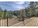Expansive wood deck offers scenic views of the surrounding forest and distant mountains at 205 Yankee Creek Trl, Evergreen, CO 80439