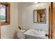 Bathroom with pedestal sink, wood trim, and a window that provides natural light and ventilation at 205 Yankee Creek Trl, Evergreen, CO 80439