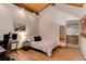 Bedroom featuring wood floors, exposed beam, and mirror feature at 205 Yankee Creek Trl, Evergreen, CO 80439