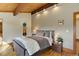 Cozy bedroom featuring exposed beam, wood floors and neutral paint at 205 Yankee Creek Trl, Evergreen, CO 80439