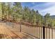 Beautiful wooden deck with metal railing overlooks a forest setting at 205 Yankee Creek Trl, Evergreen, CO 80439